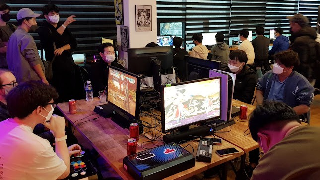 visitors playing fighting games with arcade sticks on multiple consoles at Core-A Studios in Seodaemun-gu, Seoul, South Korea